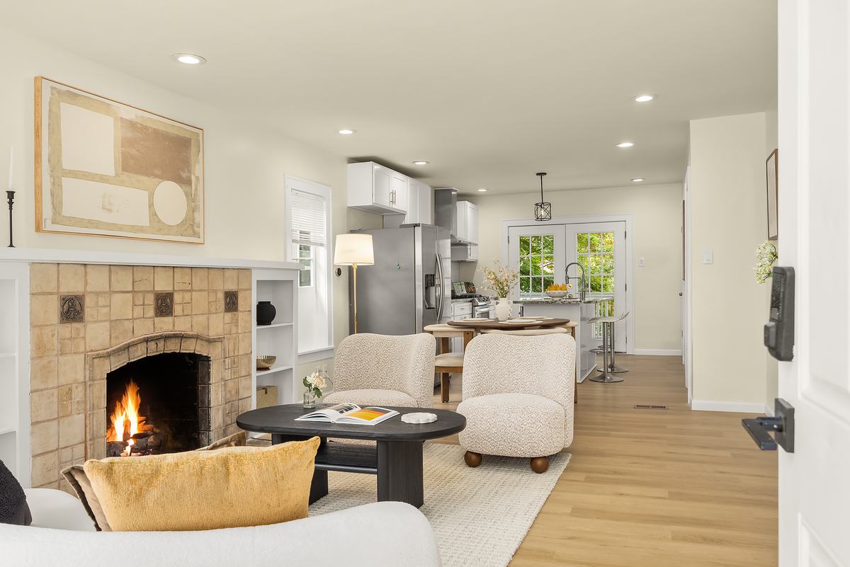 Craftsman living room with a lit tiled fireplace, built-in shelves, and boucle armchairs
